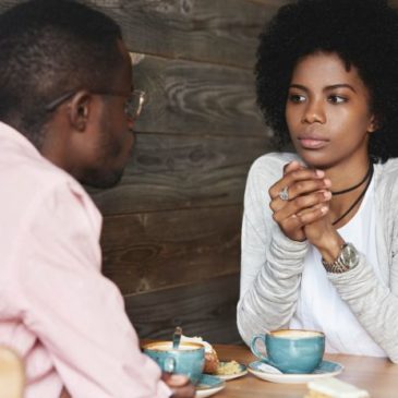 woman-talking-to-man-at-table-guesthouse