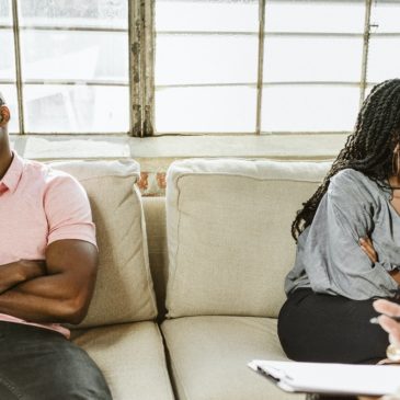 couple-sitting-on-opposite-sides-of-couch-aa