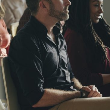 group-listening-to-speaker-seated-guesthouse