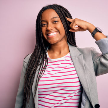 Young african american business woman standing over pink isolated background Smiling pointing to head with one finger, great idea or thought, good memory