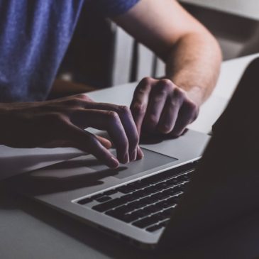 close up of person working on a laptop on table