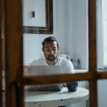 a man sitting at a table with a laptop