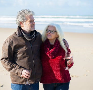 a man and a woman walking along the beach