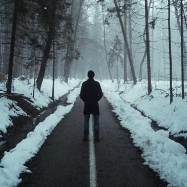 man silhouette in the middle of the road during winter