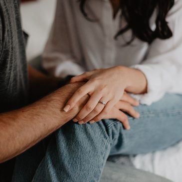 close up of couple holding hands in a supportive manner