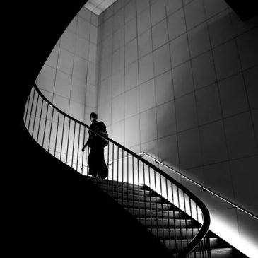 silhouette of a man climbing stairs in a black and white environment