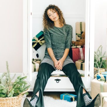 tired woman sitting in a doorstep with gift boxes behind her