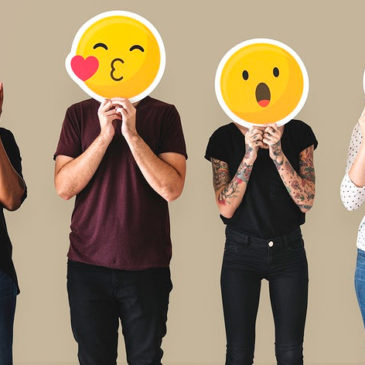 Diverse people holding emoticons