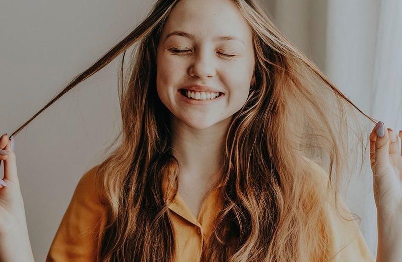Smiling woman holding her hair