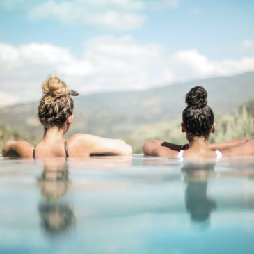two young woman in a pool with a nice landscape view