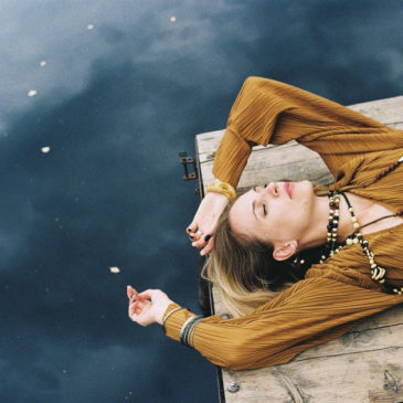 beautiful woman laying down in a wooden base by the lake