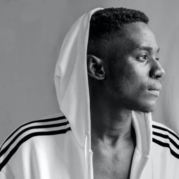 black young man in a white hoodie looking to the outside