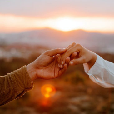 hands held together against sunset